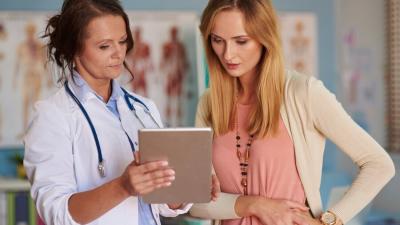 A doctor shares health information with their patient in a doctor's office.